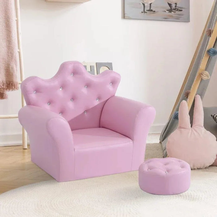 Pink kids armchair with crown backrest, crystal buttons, and matching footstool in playroom