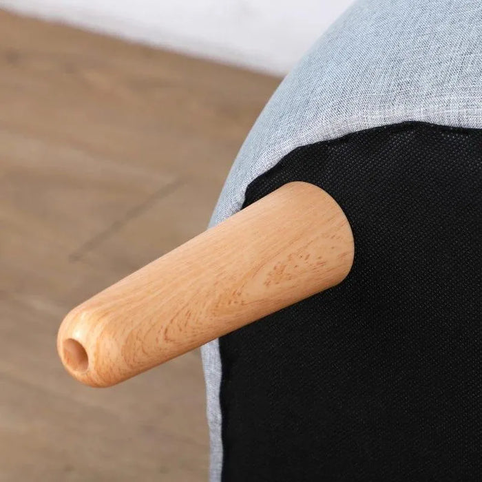 Close-up of wooden leg on grey linen kids armchair against wood floor