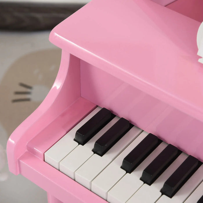 Close-up of pink kids' mini grand piano keyboard with black and white keys