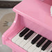 Close-up of pink kids' mini grand piano keyboard with black and white keys