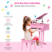 Young girl playing pink kids grand piano with matching bench, music-themed fun for children