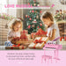 Kids opening presents by Christmas tree with pink toy piano and matching bench