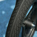 Close-up of a kids balance bike black tire with tread, blue background