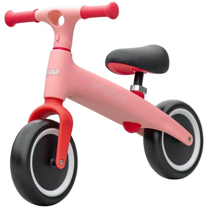 Pink kids balance bike with adjustable seat and EVA tires on white background