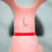Close-up of pink kids balance bike adjustable seat with red accent detail