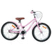 Pink kids bike with brown seat, white basket, black tires, and orange wheel reflectors