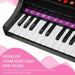 Kids black mini grand piano keyboard with labeled keys and pink music-themed background
