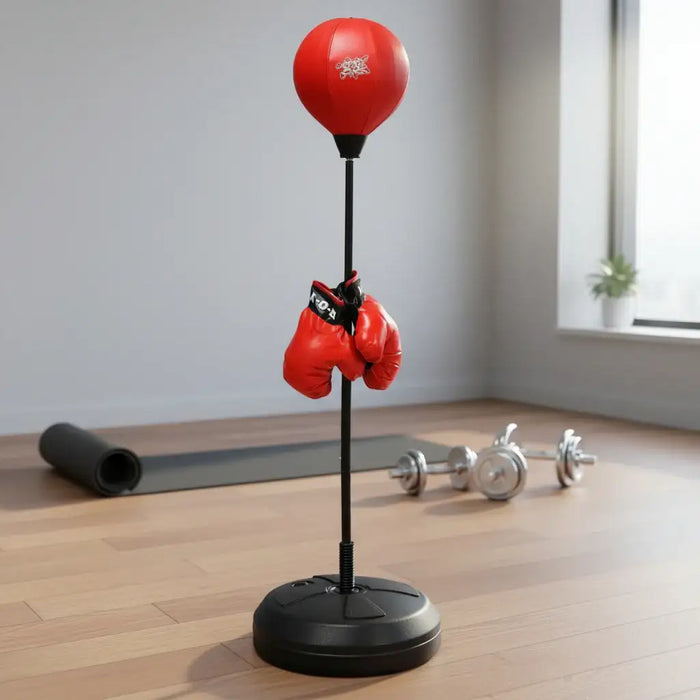 Red boxing speed bag on stand with hanging red gloves, yoga mat, and dumbbells in home gym