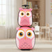 Stacked pink owl-themed kids rolling suitcases in a bright playroom with toys and furniture
