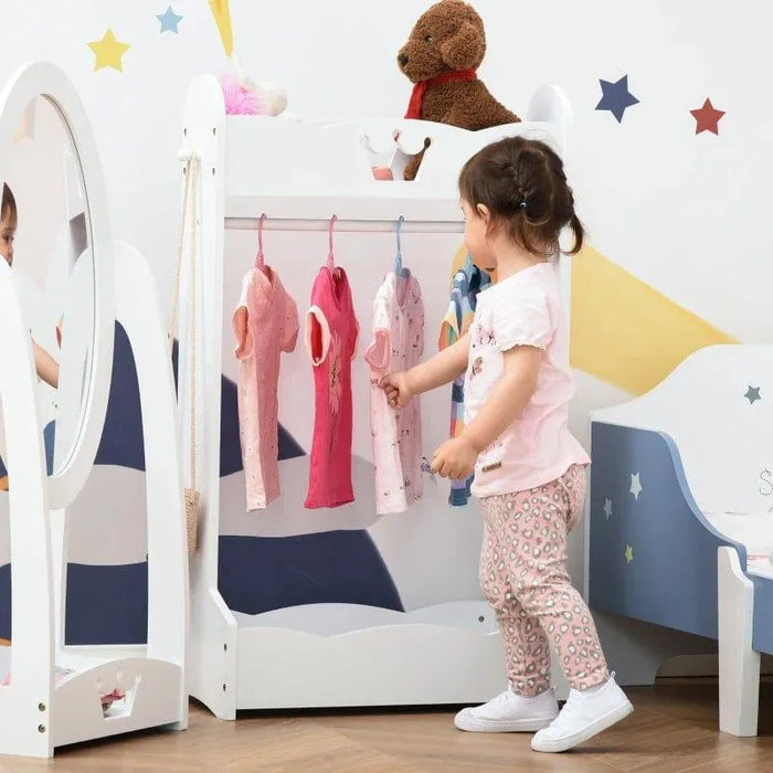 Toddler uses white crown design kids clothes rack with pine wood, mirror, and plush toy.
