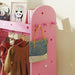 Pink kids clothes rail with star and heart decals holding children's dresses and a gray tote bag, framed panda print on top