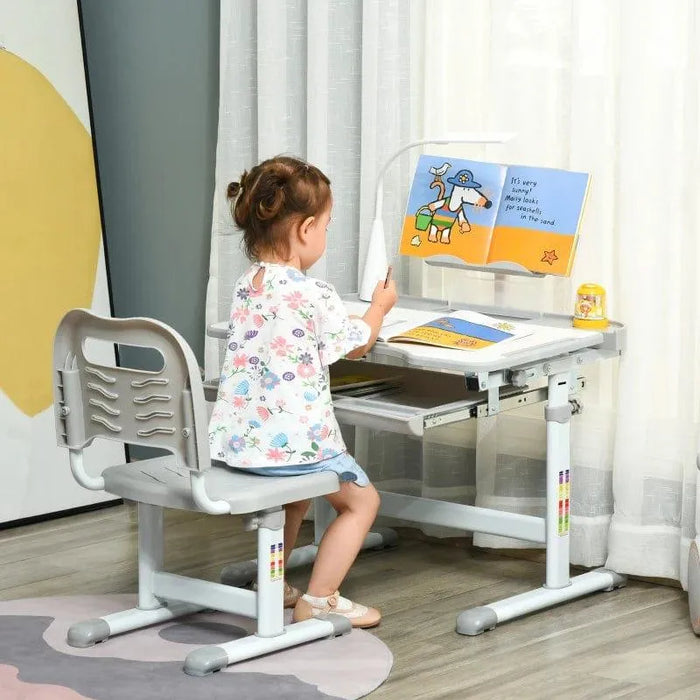 Child using grey kids adjustable desk and chair set with USB lamp and book stand
