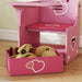 Pink kids desk and chair set with built-in storage bin holding wooden toys on hardwood floor