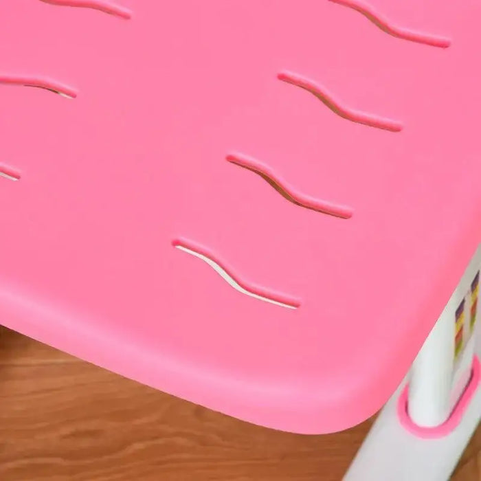 Close-up of pink kids chair with wavy ventilation slits and white legs on wood floor