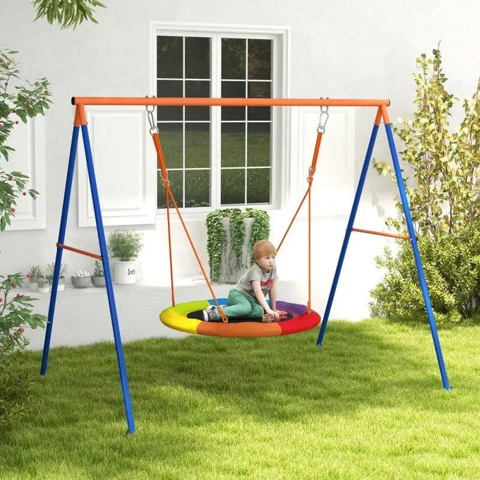 Child on colorful disc swing seat with blue and orange frame in grassy backyard