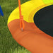 Close-up of multicoloured kids disc swing seat with orange rope on grass