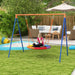 Child on colorful disc swing in garden, playset and outdoor furniture in background