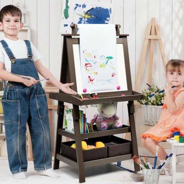 Two kids drawing at a double-sided brown easel with paper roll and storage bins