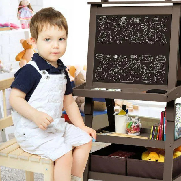 Child sitting by double-sided kids easel with chalkboard, doodles, and art supplies.