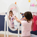Little girl at white 360° rotatable mirror dress-up set with clothes rail and crown cut-out