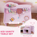 Pink kid vanity table set with various accessories on a wooden surface.