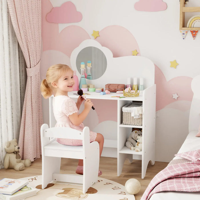 Child playing with makeup in a child-sized vanity set against a pink cloud-themed wall.