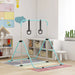 Adjustable kids gymnastics bar with black rings in bright playroom with storage shelves and colorful rug