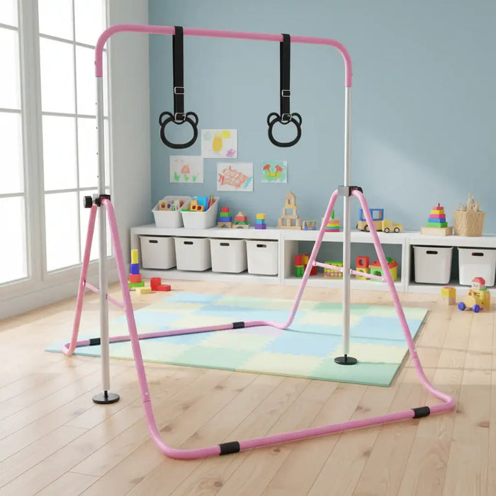 Pink and white foldable kids gymnastics bar with black hanging rings in playroom with toys and storage