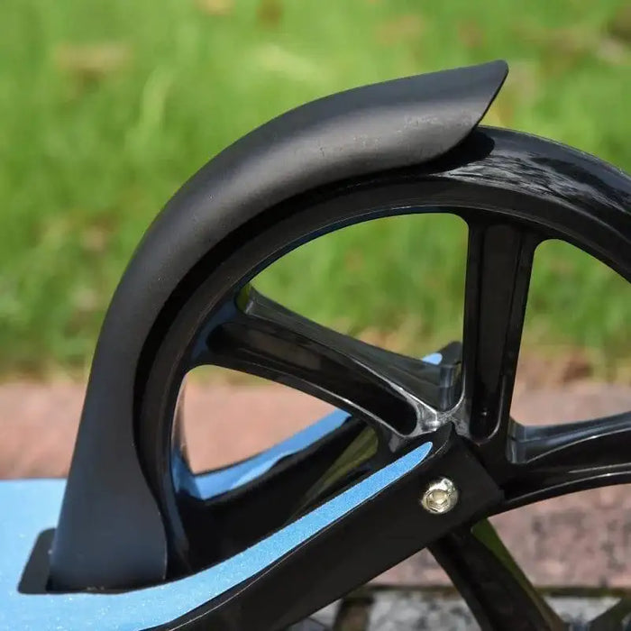 Close-up of black rear wheel and fender on kids folding scooter outdoors