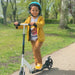Child riding white folding kick scooter with helmet in park, adjustable handlebar visible