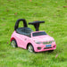 Pink kids ride-on car with steering wheel and black seat on green grass