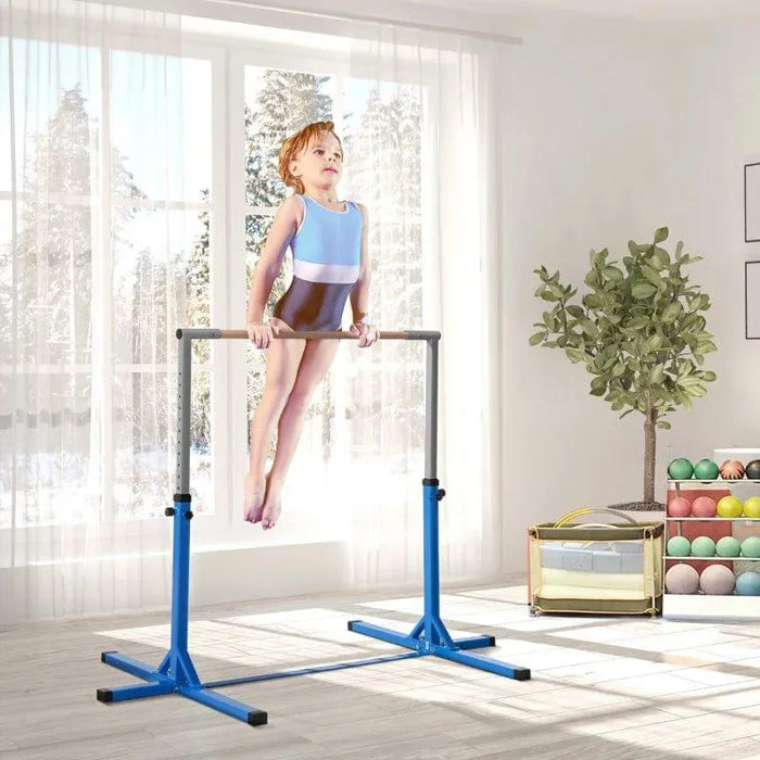 Child on blue adjustable kids gymnastic horizontal bar in bright indoor playroom