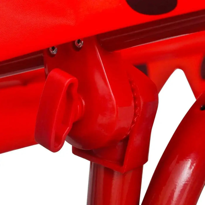 Close-up of red kids ladybird swing seat frame with sunshade canopy attachment.