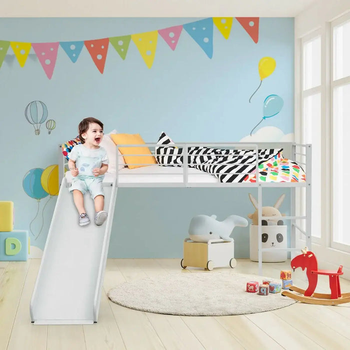 Child sliding down slide attached to white loft bed in light blue nursery with colorful decor and toys