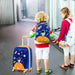 Two children with colorful backpacks and a suitcase in an airport setting.