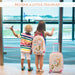 Two children at an airport with a suitcase and airplane toy, text 'Become a Little Traveler' above.