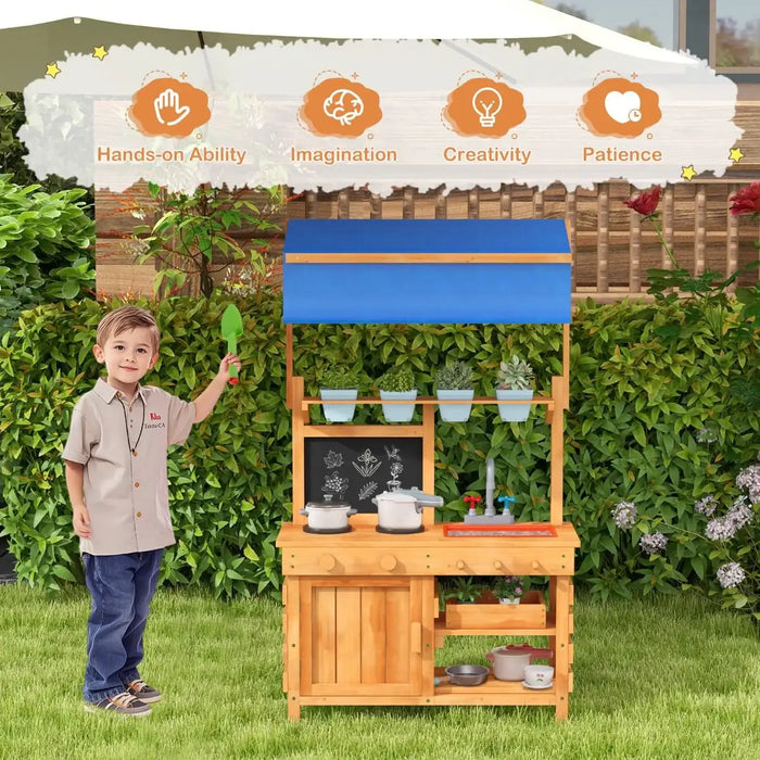Child playing with fir wood outdoor play kitchen with blue adjustable canopy and toy cooking set