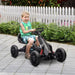 Young boy rides black kids pedal go kart with adjustable seat and handbrake on paved path