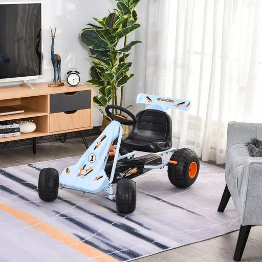 Kids blue and orange pedal go-kart with handbrake and gear lever indoors on rug