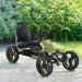 Green and black kids pedal go kart with handbrake and chain drive on outdoor path