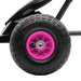 Close-up of pink and black kids pedal go-kart wheel with thick tread and suspension
