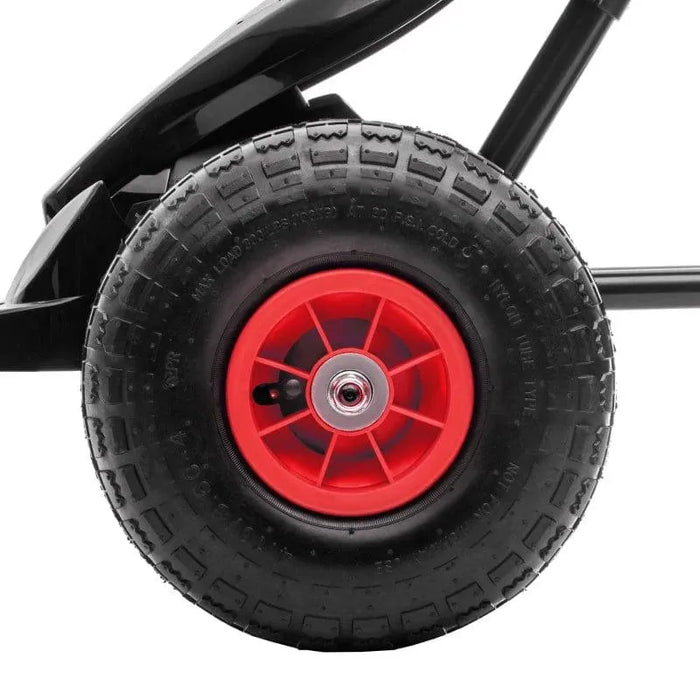 Close-up of red and black pedal go-kart wheel with shock-absorbing suspension