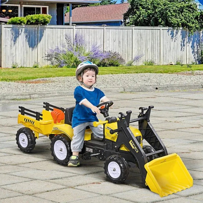 Child riding yellow pedal go-kart tractor with excavator and trailer outdoors