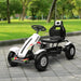 White and black kids pedal go-kart with adjustable seat and handbrake on park path