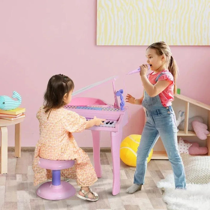 Two girls playing with pink kids' piano keyboard set and microphone in a pastel playroom