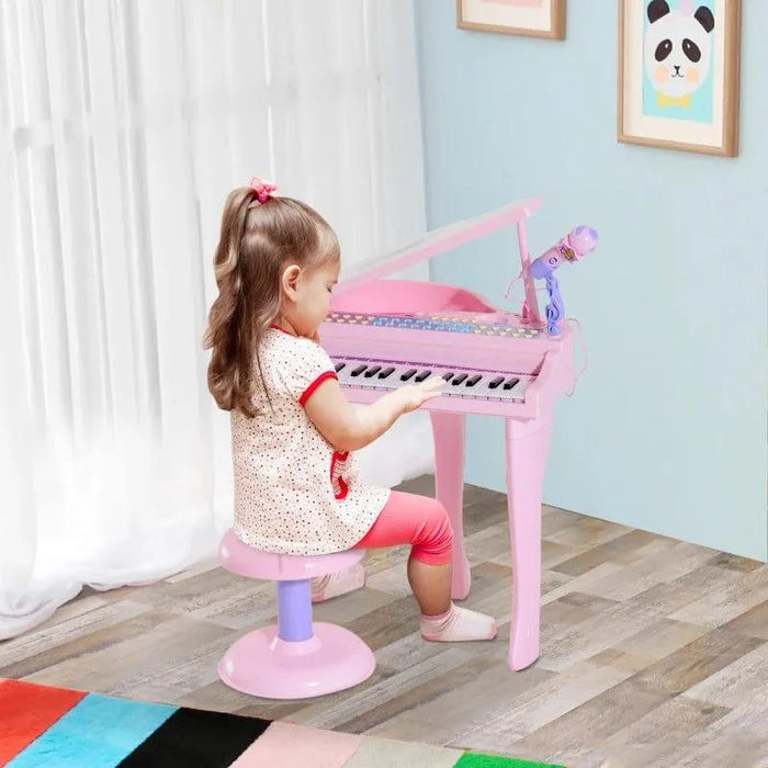 Little girl playing pink kids mini grand piano keyboard set with stool and microphone indoors
