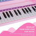 Kids pink 37-key mini piano keyboard close-up with musical notes and white black keys