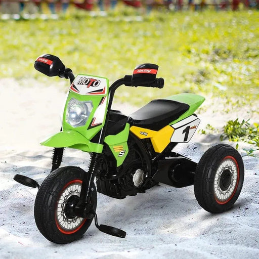 Green kids ride-on tricycle with pedals, side wheels, and racing decals on sand outdoors