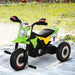 Green kids ride-on tricycle with pedals, side wheels, and racing decals on sand outdoors