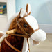 Brown and white kids rocking horse toy with cowboy theme and plush texture indoors